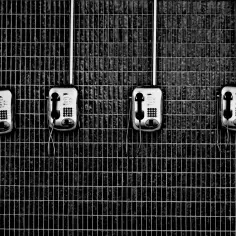 Cztery telefony na kafelkowanej ścianie. Może to być miejsce, gdzie wypełnia się wniosek o kontakt telefoniczny z tymczasowo aresztowanym wzór.