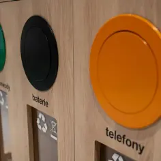 Drewniany pojemnik do segregacji odpadów z otworami na kable, baterie i telefony.