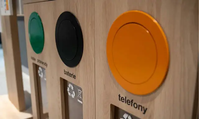 Drewniany pojemnik do segregacji odpadów z otworami na kable, baterie i telefony.